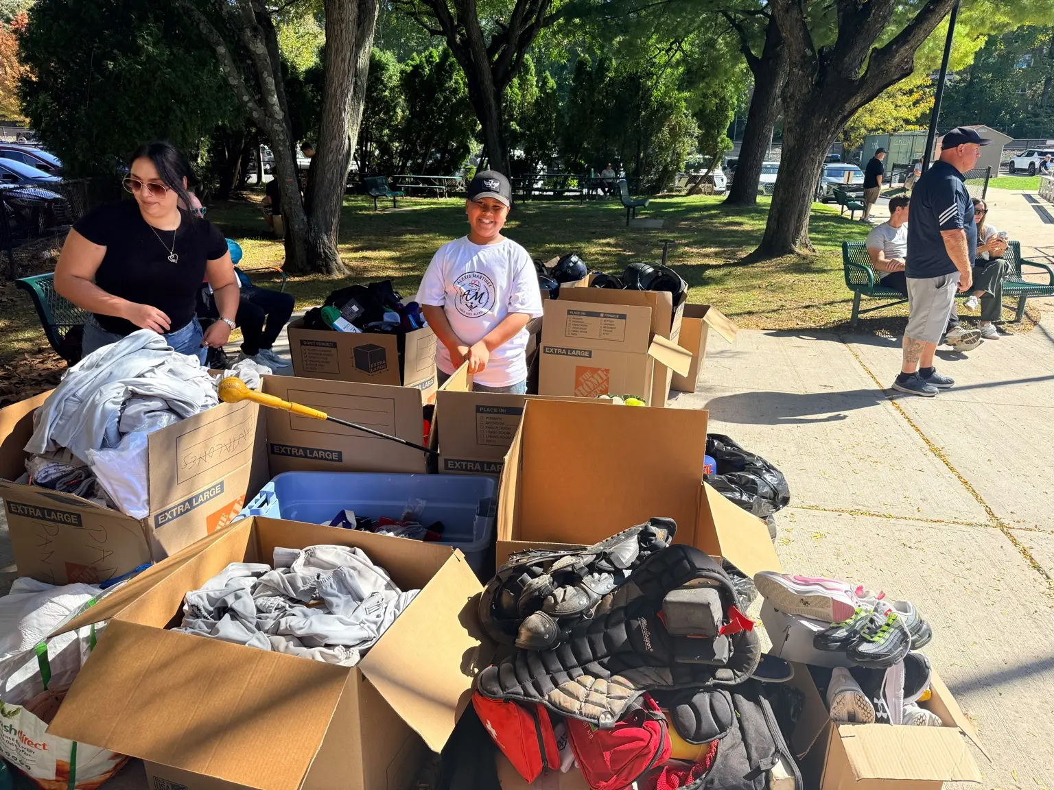 Volunteers organizing donated baseball equipment and boxes