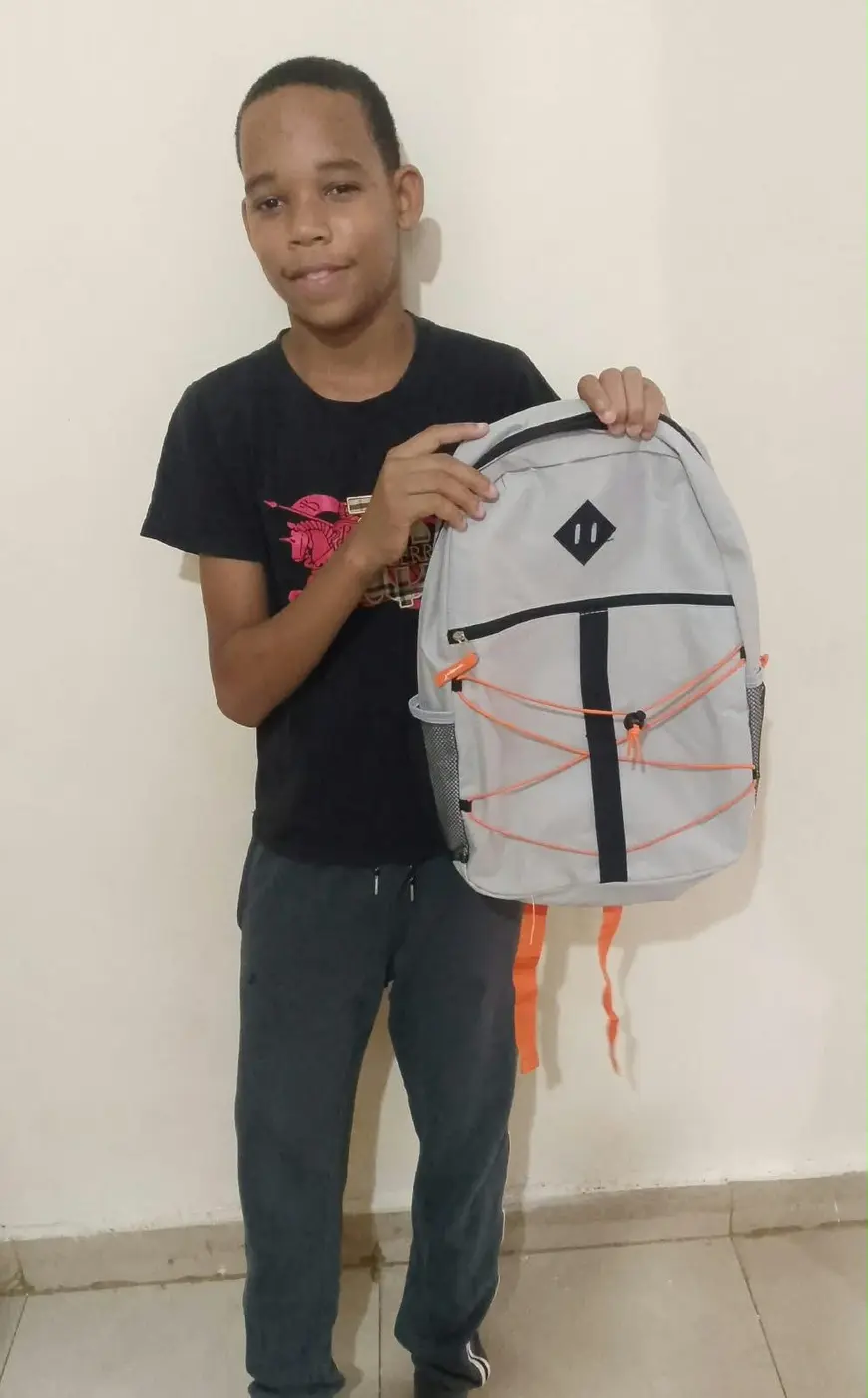 Young person holding a new gray backpack