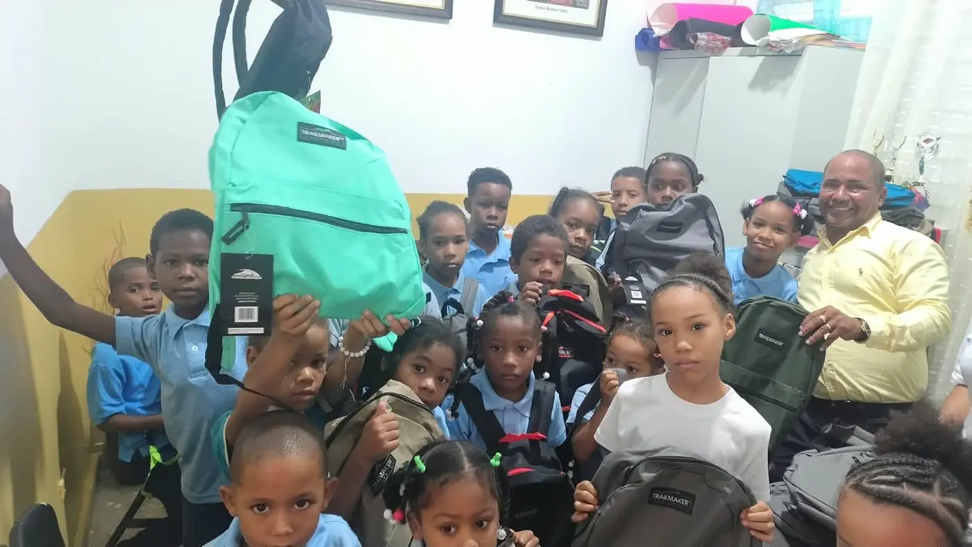 Schoolchildren proudly showing their new backpacks