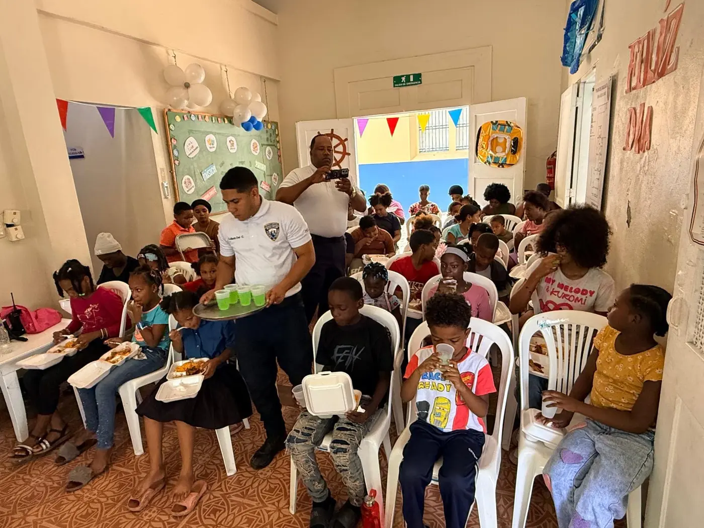 Volunteers serving children during the community gathering
