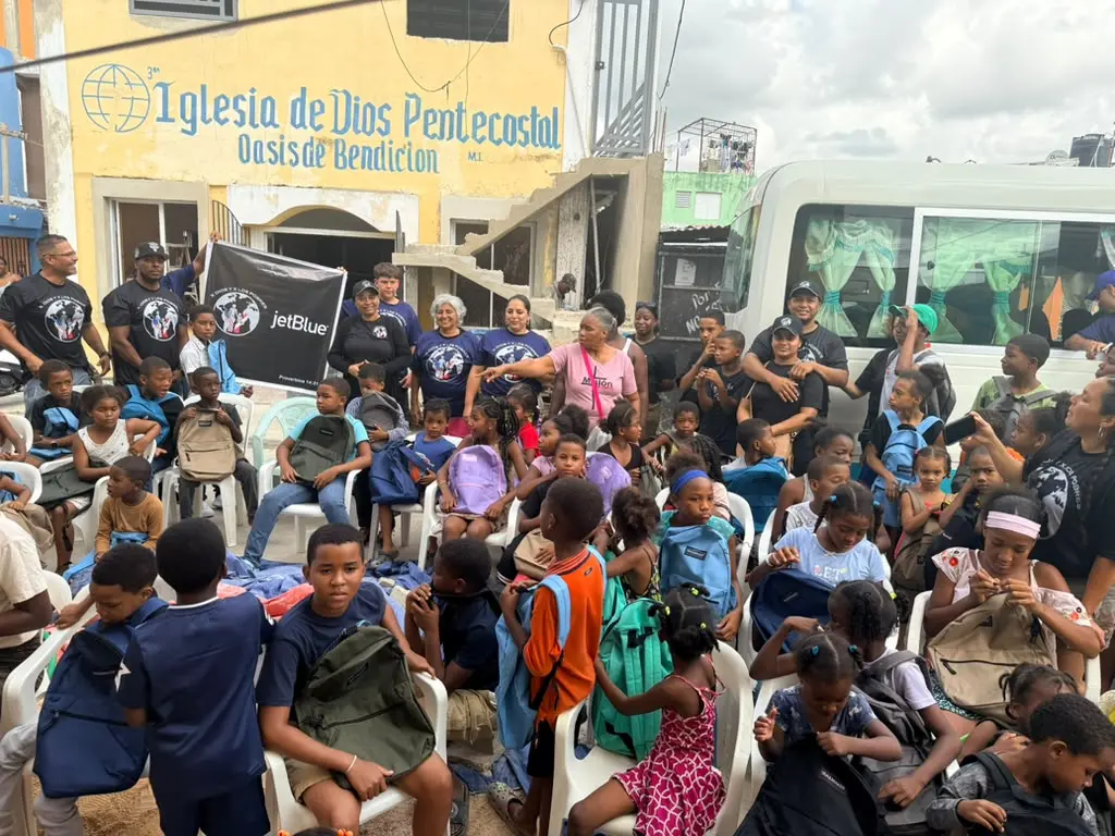 Children and volunteers gathered outside after the backpack distribution