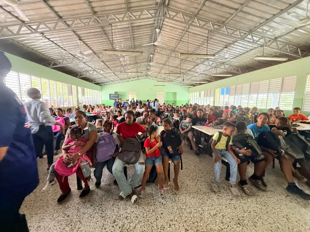 Children gathered inside a school for the backpack drive