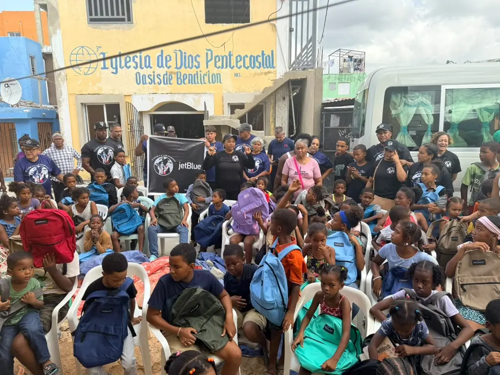 Children proudly carrying their backpacks after the distribution